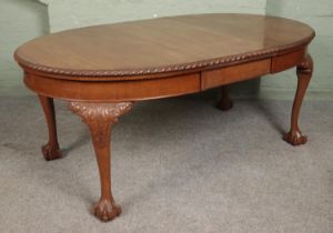 An oval mahogany dining table with ball and claw feet, including one leaf. Hx74cm Wx183cm Dx108cm