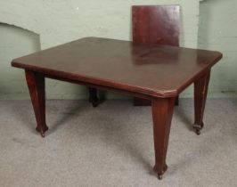 A rectangular mahogany extending dining table with square tapering legs raised on castors. Hx74cm