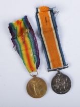 A pair of WWI medals with ribbons to include Victory medal and silver British War medal. Both