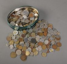 A tin of world coins. Includes American, French, Cyprian, 1942 South Africa shilling, Portuguese