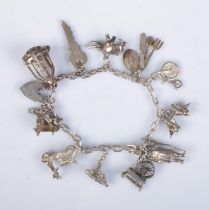 A silver charm bracelet featuring eleven charms including Beefeater, Elephant, Cutlery, Key,