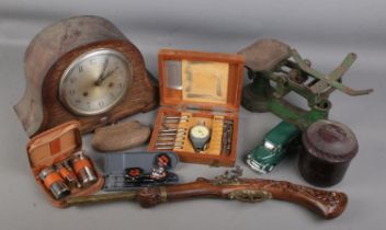 A box of assorted collectables. Includes mantel clock, bakelite tobacco jar, replica pistol, John