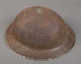 A British World War Two Brodie helmet with chin strap.