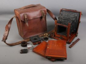 A leather case with contents of bellows plate camera accessories. Marked for Horne & Thornthwaite.