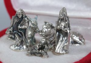 A cased miniature five piece white metal nativity scene.