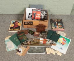 A box of miscellaneous. Includes John Duggan watercolour, carved oak pipe rack, books, garden