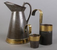 A brass bound toleware brass banded measuring jug and two measuring cups, just stamped â€˜ARMY &