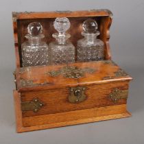 A Victorian oak tantalus with brass mounts, fitted interior with secret drawer and plaque stating "