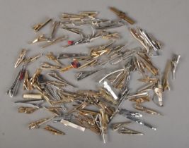 A very large quantity of yellow and white metal tie clips/slides.