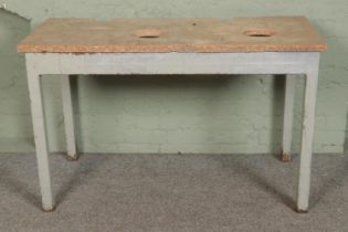 A steel work bench with wooden chip board top. Hx79cm Wx128cm Dx62cm