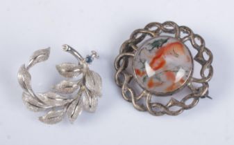 Two silver brooches. Includes moss agate example and floral spray with sapphire coloured stone.