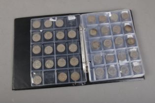 An album of six pence coins ranging from 1946 onwards together with a page of one shillings 1948