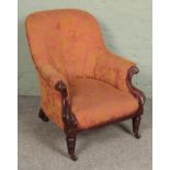 A Victorian mahogany armchair with scrolling frame on brass castors.