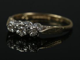 An 18ct gold three stone diamond ring in illusion setting. Size K. 1.6g.