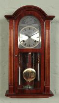 A Highlands mahogany twin weight wall clock. Chiming on a coiled gong.