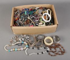 A box of assorted costume jewellery to include bracelets, necklaces, earrings, etc.