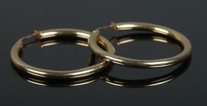 A pair of 9ct Gold hooped earrings. Total weight: 2.6g. Slight dent to one example.