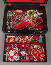 A jewellery case with contents of costume jewellery. Includes brooches, pendants, earrings, chains