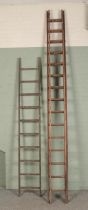 A large set of wooden extension ladders and a single set of ladders