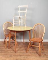 A light oak drop-leaf table with Formica top, together with a pair of 'Goldenpine' chairs and one