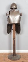 A replica medieval Norman helmet and with breast & back plates with tassets attached displayed on