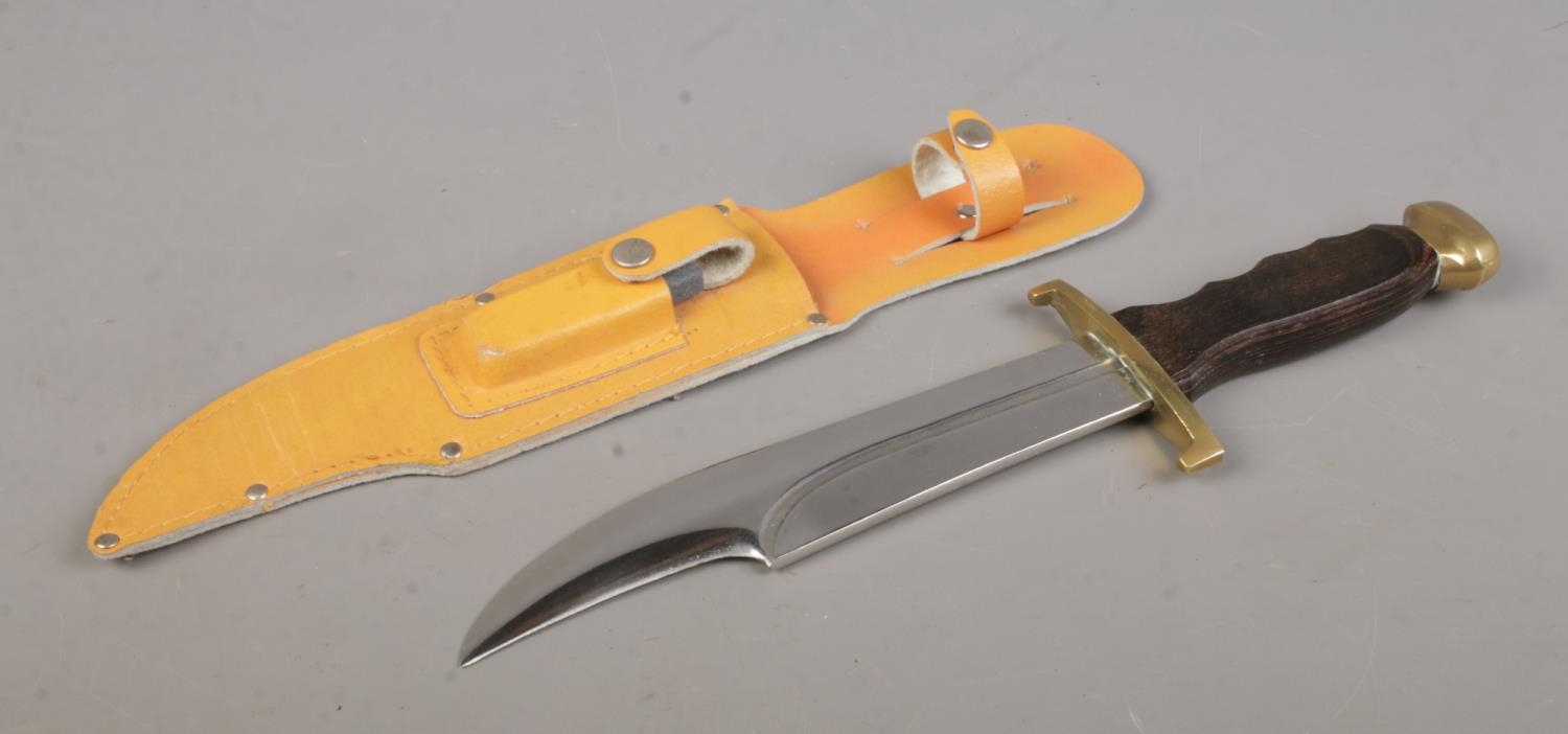 A 'Crocodile Hunter' bowie knife in sheath, with sharpening stone. Blade length 8.25 inches.