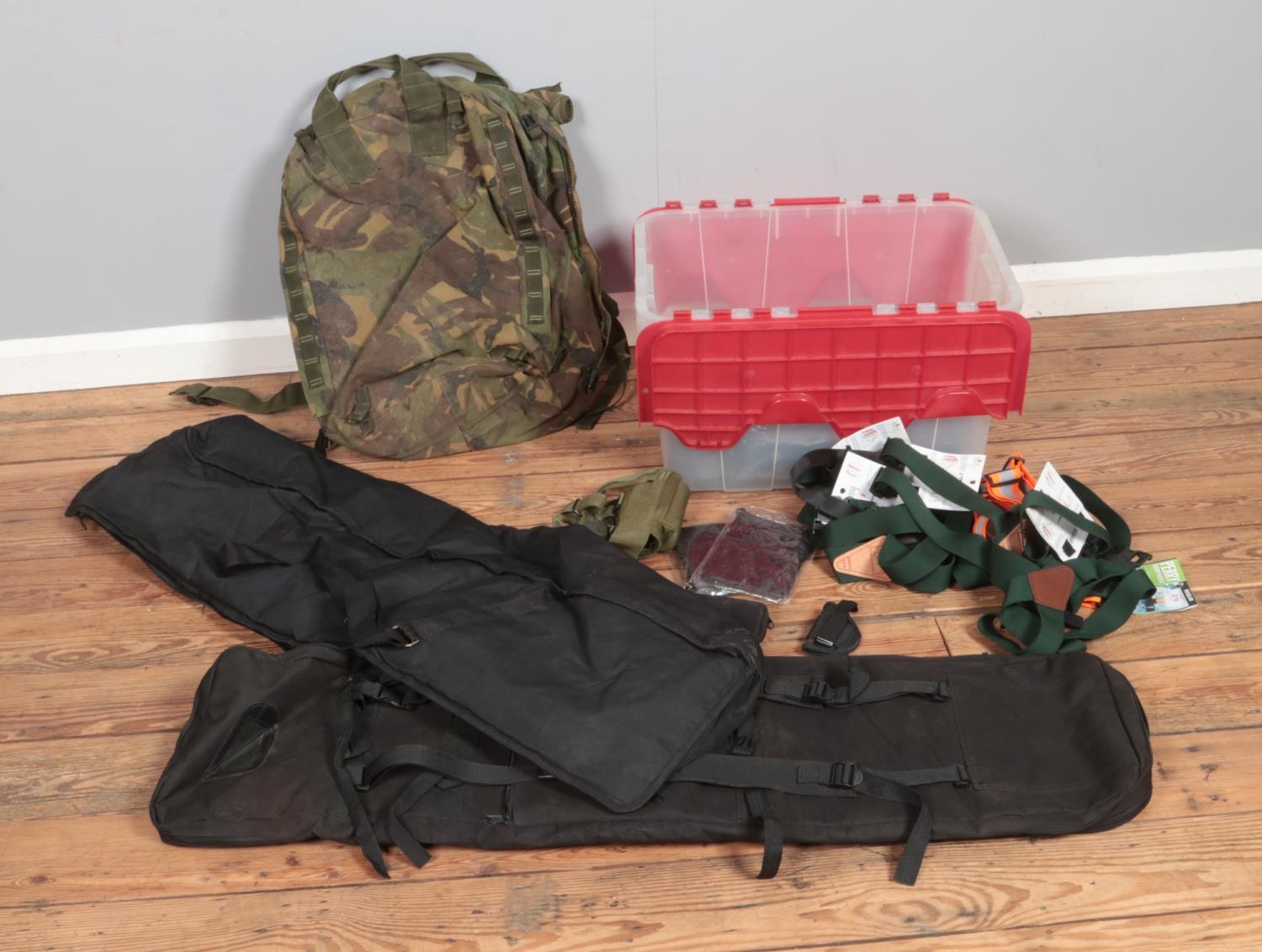 A box of assorted carry cases and bags to include Rifle carry cases and military Bergen backpack.