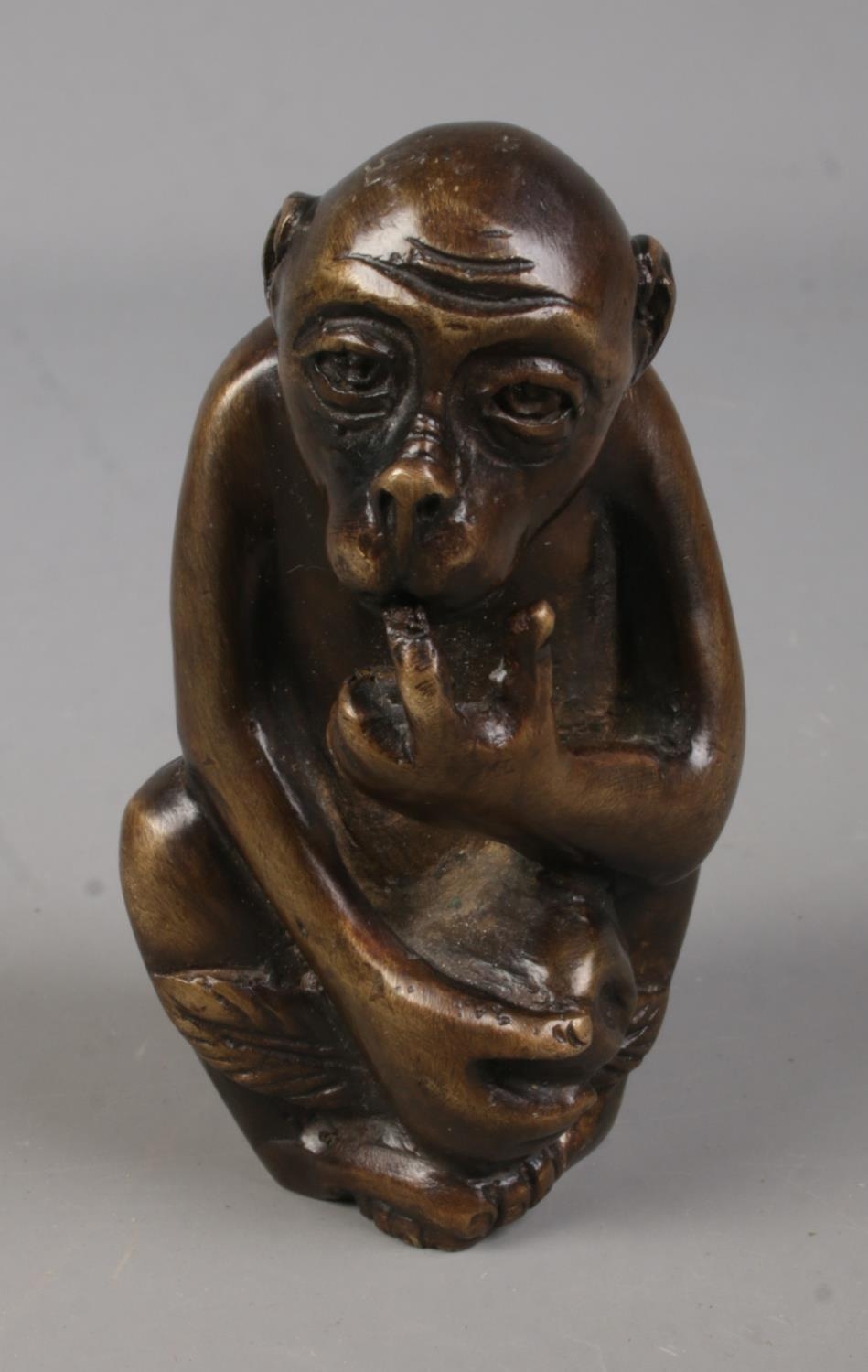 A bronze figure formed as a seated monkey. Approx. height 8cm.