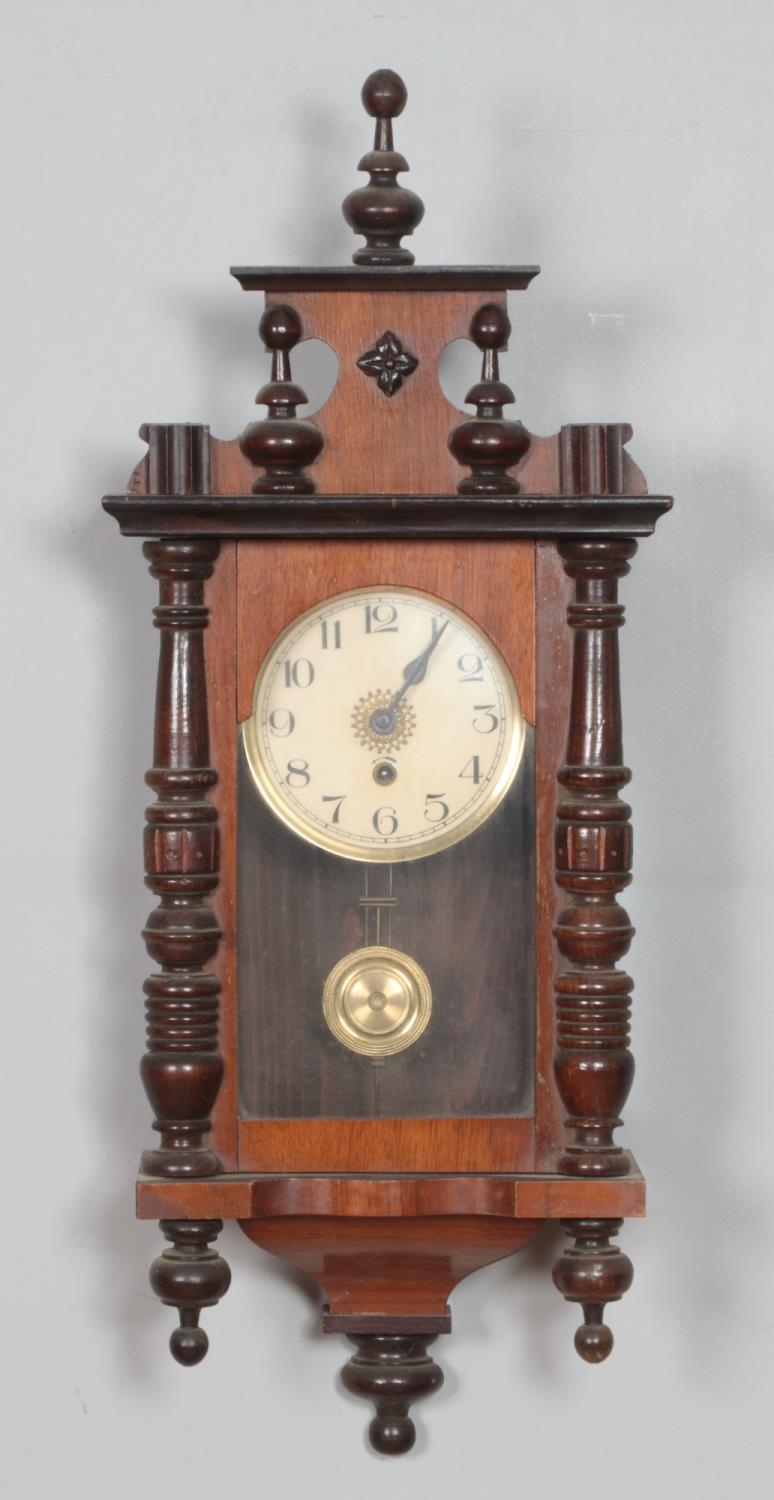 A mahogany wall clock with enamel face, turned columns and finials. Hx71cm