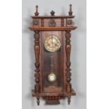 A Victorian mahogany wall clock with turned and carved design. Hx83cm