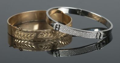 Two hinged bangles; one 9ct rolled gold example with foliate detailing, the other Swarovski, set
