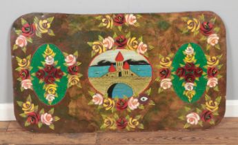 A decorative painted wall plaque mounted on chipboard back depicting bridge over canal bordered by