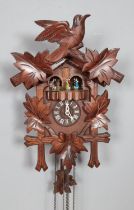 A German cuckoo clock with weights and wooden pendulum. 43cm from base of clock to top of pediment.