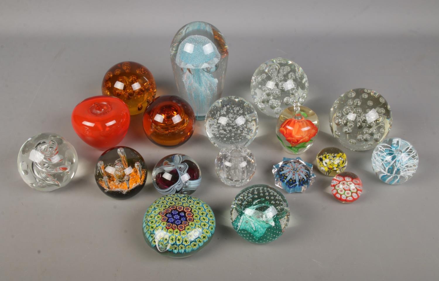 A good collection of glass paperweights to include large jellyfish, floral, apple and millefiori