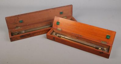 Two wooden cased brass sliding rules; one marked for 'Drawing Office Supplies Ltd'.