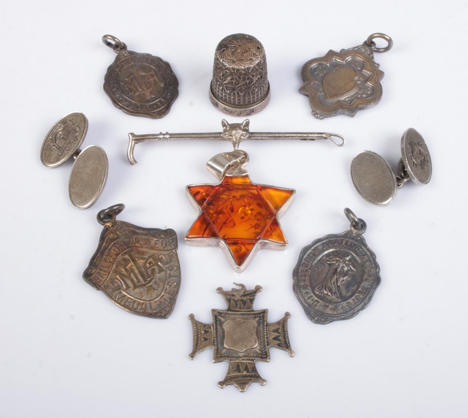 A collection of silver oddments, to include riding crop badge depicting a fox head, fobs,