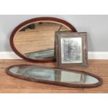 Three bevelled edge glass mirrors including two oval examples.