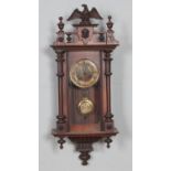 A Victorian mahogany cased wall clock with carved eagle design, circular brass and enamel dial inset