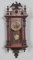 A Victorian mahogany cased wall clock with carved eagle design, circular brass and enamel dial inset