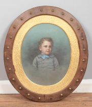 A oval framed mixed media painting depicting a young boy in formal attire. Signed 'Van Loo' to the