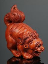 A hand carved hardwood netsuke of Foo Dog/Baby Dragon. Signed.