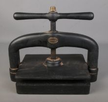 A cast iron hand crank book press by Perry & Co London.