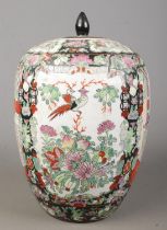 An Oriental lidded vase. Having hand painted decoration depicting figures, birds and flowers. Height