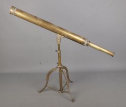 A vintage brass library telescope on brass tripod base.