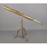 A vintage brass library telescope on brass tripod base.