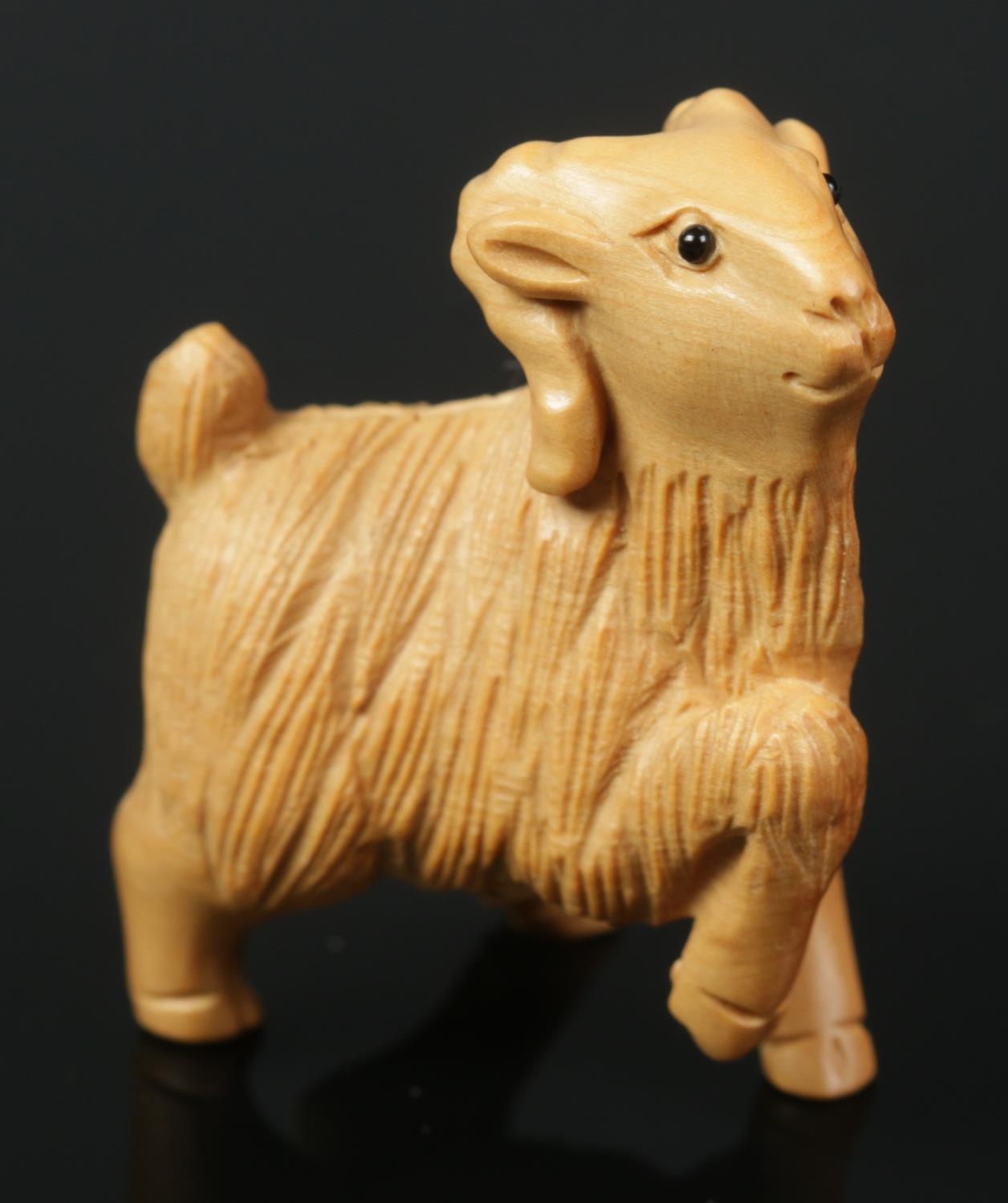 A hand carved hardwood netsuke of a goat.