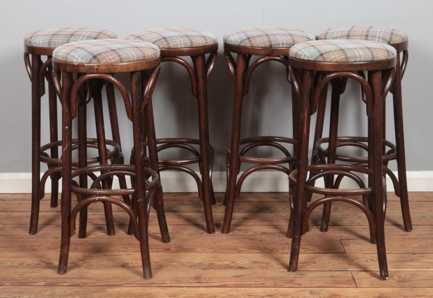 A set of six bentwood bar stools, with chequered pattern fabric seat pads. Height: 78cm.