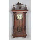 A Victorian mahogany wall clock flanked by turned supports and carved detailing. Hx80cm