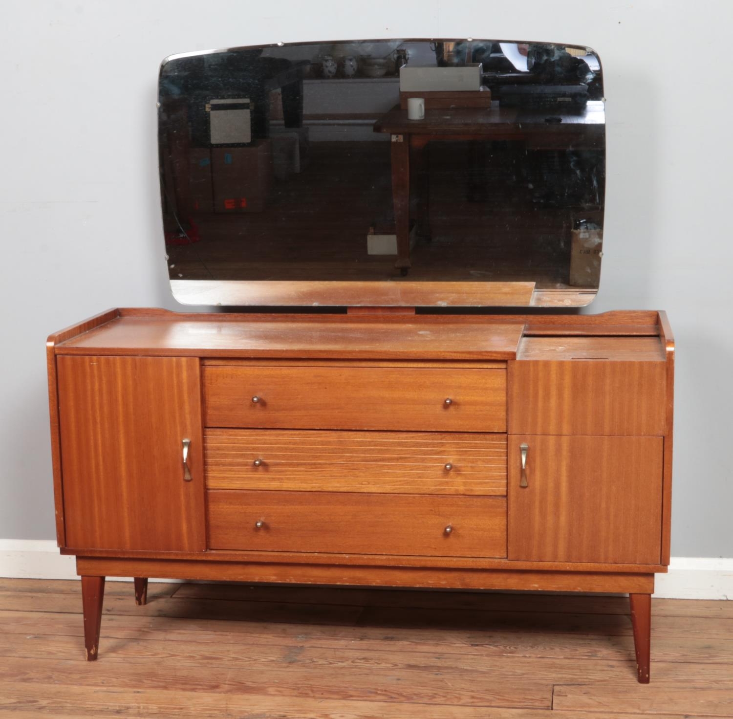 A mid-century Austinsuite teak dressing table, with three drawers flanked by two cupboard doors