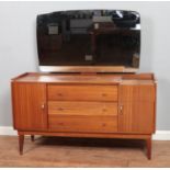 A mid-century Austinsuite teak dressing table, with three drawers flanked by two cupboard doors